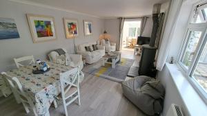 a living room with a table and chairs and a living room at Willow in Saint Mawes