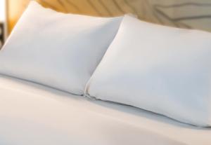 - une paire d'oreillers blancs sur un lit dans l'établissement B&B HOTEL Saint-Pierre-en-Faucigny Bonneville, à Saint Pierre en Faucigny