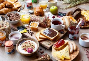 une table avec de nombreux types différents de produits pour le petit-déjeuner dans l'établissement B&B HOTEL Saint-Pierre-en-Faucigny Bonneville, à Saint Pierre en Faucigny