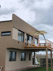 een huis met een terras met een paraplu erop bij Casa en Playa Dorada in Playa Dorada