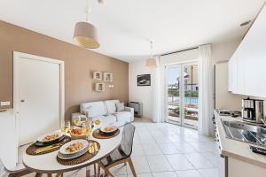 a kitchen and living room with a table and a couch at Residenza Miralago II by Wonderful Italy in Desenzano del Garda