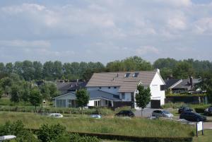 a large white house with a gambrel roof at La Cabane Penthouse in Nieuwvliet-Bad