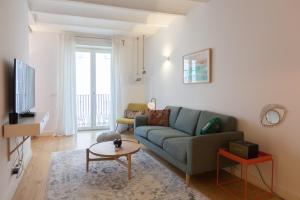 uma sala de estar com um sofá e uma mesa em FLH Bairro Alto Balcony with River View em Lisboa