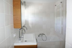 a bathroom with a sink and a bath tub at La Cabane Penthouse in Nieuwvliet-Bad +25 photos