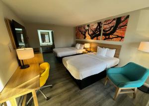 ein Hotelzimmer mit 2 Betten, einem Schreibtisch und einem Stuhl in der Unterkunft Days Inn by Wyndham Emporia in Emporia