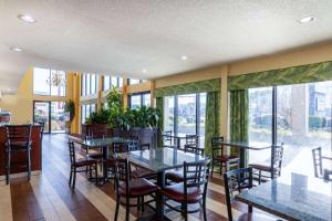 un restaurante con mesas, sillas y ventanas grandes en Days Inn by Wyndham Florence/I-95 North, en Florence