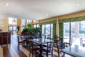 a restaurant with tables and chairs and large windows at Days Inn by Wyndham Florence/I-95 North in Florence