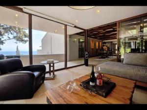 un soggiorno con un divano e un tavolo con bottiglie di vino di Corfu Dream Holidays Villa a Perama