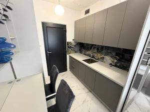 a kitchen with a table and a black door at Apartman "INSOMNIA" in Slavonski Brod