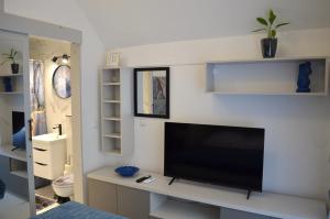 ein Wohnzimmer mit einem Flachbild-TV an einer weißen Wand in der Unterkunft Apartman "INSOMNIA" in Slavonski Brod