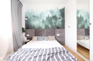 sypialnia z łóżkiem i obrazem na ścianie w obiekcie Słodowiec Residence II w Warszawie