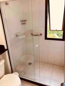 um chuveiro com uma porta de vidro na casa de banho em Angra dos Reis - Porto Bali - Apartamento no Complexo Mercur em Angra dos Reis