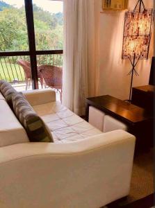 uma sala de estar com um sofá e uma mesa em Angra dos Reis - Porto Bali - Apartamento no Complexo Mercur em Angra dos Reis