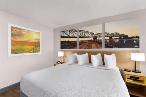 a bedroom with a white bed and a bridge at Days Inn by Wyndham Carlisle in Carlisle