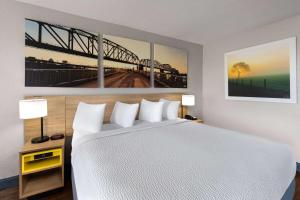 a bedroom with a large bed with two paintings on the wall at Days Inn by Wyndham Carlisle in Carlisle +24 photos