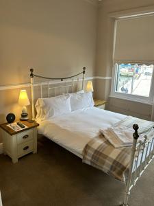 ein Schlafzimmer mit einem weißen Bett und einem Fenster in der Unterkunft Admiral MacBride in Plymouth