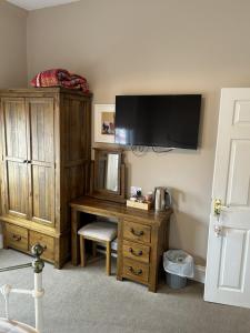 Zimmer mit einem Schreibtisch und einem TV an der Wand in der Unterkunft Admiral MacBride in Plymouth