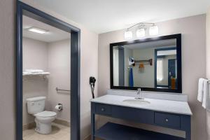a bathroom with a sink and a toilet and a mirror at Days Inn by Wyndham Carlisle in Carlisle +24 photos