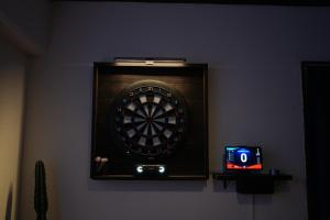 un tablero de dardos en una pared con un reloj en CINEMA RESORTS 4, en Motobu