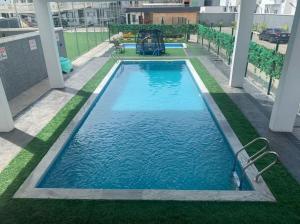 a swimming pool with blue water in a building at Cozy 4 Beds Apart-24Hrs Elect/WIFI/Security in Lagos