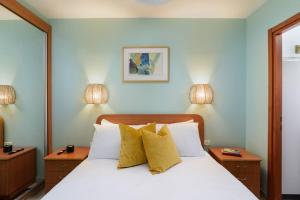 a bedroom with a white bed with yellow pillows at Neta's Central Gem with Bomb Shelter in Tel Aviv in Tel Aviv