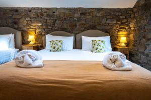 Dos toallas en una cama con almohadas. en Ewe Time Holiday Barn, en Kelbrook