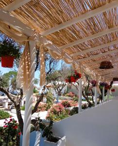 une pergola en bois dans un jardin fleuri dans l'établissement Errika's Sweet Home, à Provatas