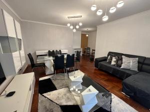 a living room with a couch and a table at FUNCHAL APARTMENT WITH POOL - Garajau 2 in Caniço