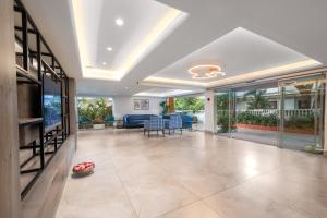 uma grande sala de estar com portas de vidro e uma televisão em Quality Inn Ocean Palms Goa em Calangute