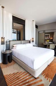Grand Hyatt Abu Dhabi Hotel & Residences Emirates Pearl في أبوظبي: غرفة نوم بسرير ابيض كبير وطاولة