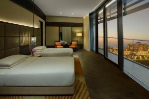 Grand Hyatt Abu Dhabi Hotel & Residences Emirates Pearl في أبوظبي: غرفة نوم بسرير وإطلالة على مدينة