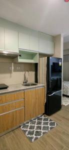 a kitchen with a sink and a black refrigerator at Le Palis Suite 