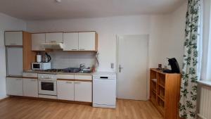 a kitchen with white cabinets and a white refrigerator at Holiday Apartment 2 Villach in Villach