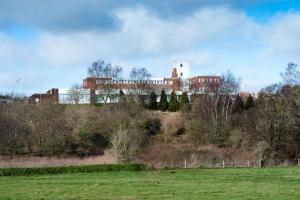 a building on top of a hill with a field at Ox Hotel Carlisle in Carlisle