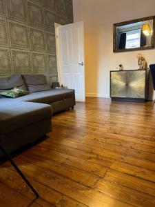 Inviting 3-Bed Apartment in Newcastle upon Tyne في نيوكاسل أبون تاين: غرفة معيشة مع أريكة وأرضية خشبية