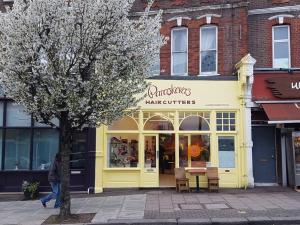 ロンドンにあるHarlesden Heightsの木前黄色い店舗