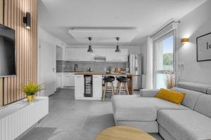 Perle Toulousaine في تولوز: غرفة معيشة مع أريكة ومطبخ