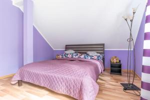 a bedroom with a pink bed with purple walls at Leśna ostoja nad Pilicą in Lechanice