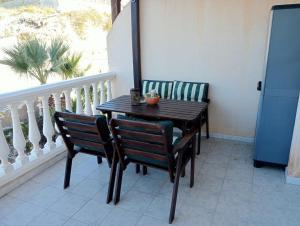 a wooden table and chairs on a balcony at Balcón al mar in Adra