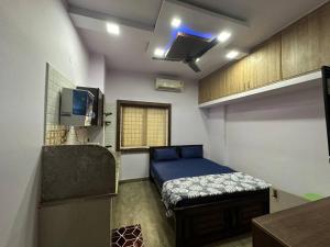 バンガロールにあるAmazing AC Studio in E City 1F 102のベッド1台とテレビが備わる小さな客室です。