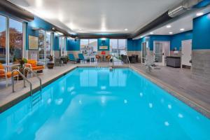 una piscina con agua azul en una habitación de hotel en Hampton Inn Green Bay Stadium, Wi en Green Bay