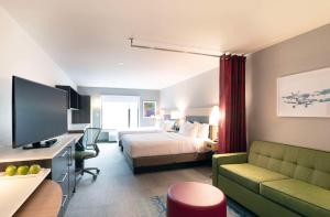 une chambre d'hôtel avec un lit et un canapé dans l'établissement Home2 Suites By Hilton Quebec City, à Québec