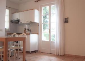 a kitchen with a window and a table with chairs at Residence Le Mimose in Procchio