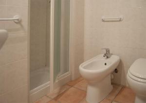 y baño con aseo, ducha y bidet. en Residence Le Mimose, en Procchio