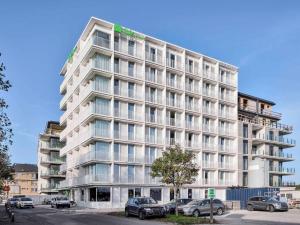 un grande edificio bianco con auto parcheggiate di fronte di ibis Styles Bredene a Bredene