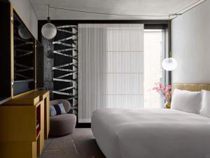 sypialnia z białym łóżkiem i piwniczką z winami w obiekcie Nobu Hotel London Shoreditch w Londynie