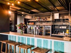 een bar met 2 krukken en een bar met drankjes bij ibis Styles Bredene in Bredene