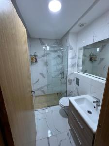 La salle de bains est pourvue d'une douche, de toilettes et d'un lavabo. dans l'établissement Luxury AÏDA FLAT, à Tanger