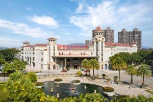 a large building with a fountain in front of it at Hilton Garden Inn Huizhou North Railway Station in Huizhou