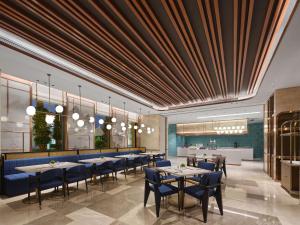 a restaurant with tables and chairs and a bar at Hilton Garden Inn Huizhou North Railway Station in Huizhou